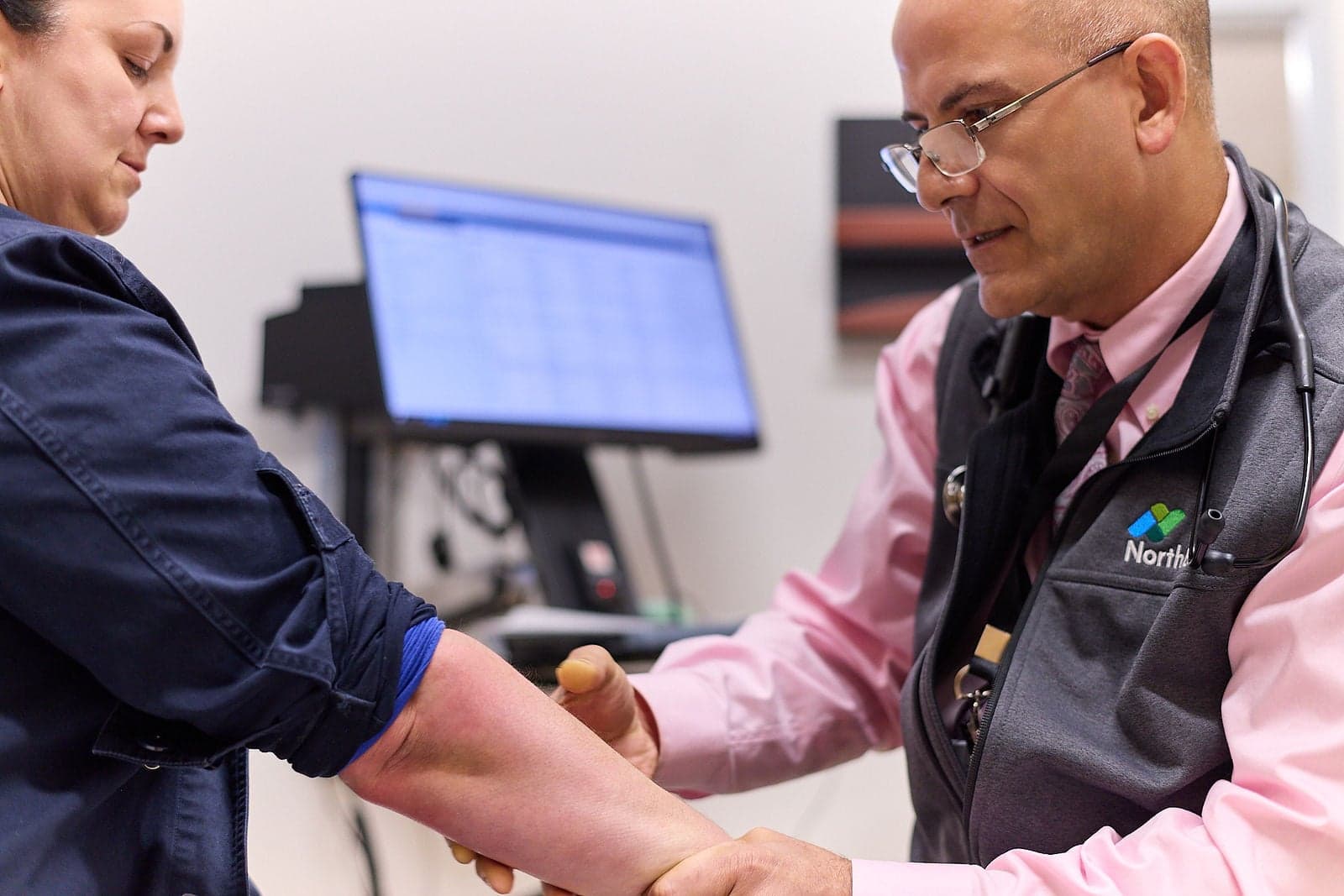 A Northbay Health doctor examines a woman’s forearm in an exam room.