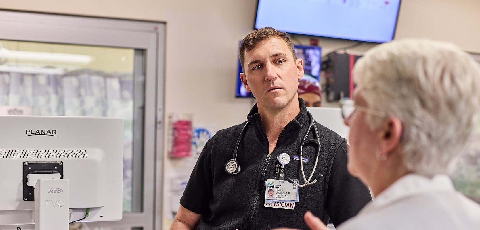 Dr. Blake Cleveland speaks to another person in the emergency department