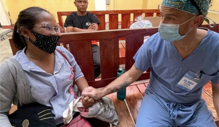 Podiatrist Dr. Miller sits with the mother of a patient during his medical mission to Bayambang in Pangasinan Province.