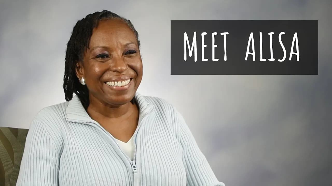 Smiling woman wearing a light blue pinstriped cardigan with "MEET ALISA" text overlay in white letters on a dark banner