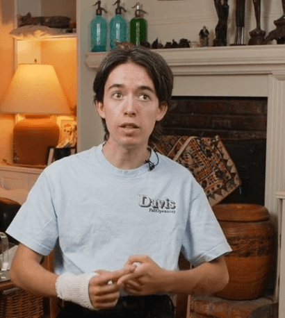 Young boy with wrap over wrist sitting in home.