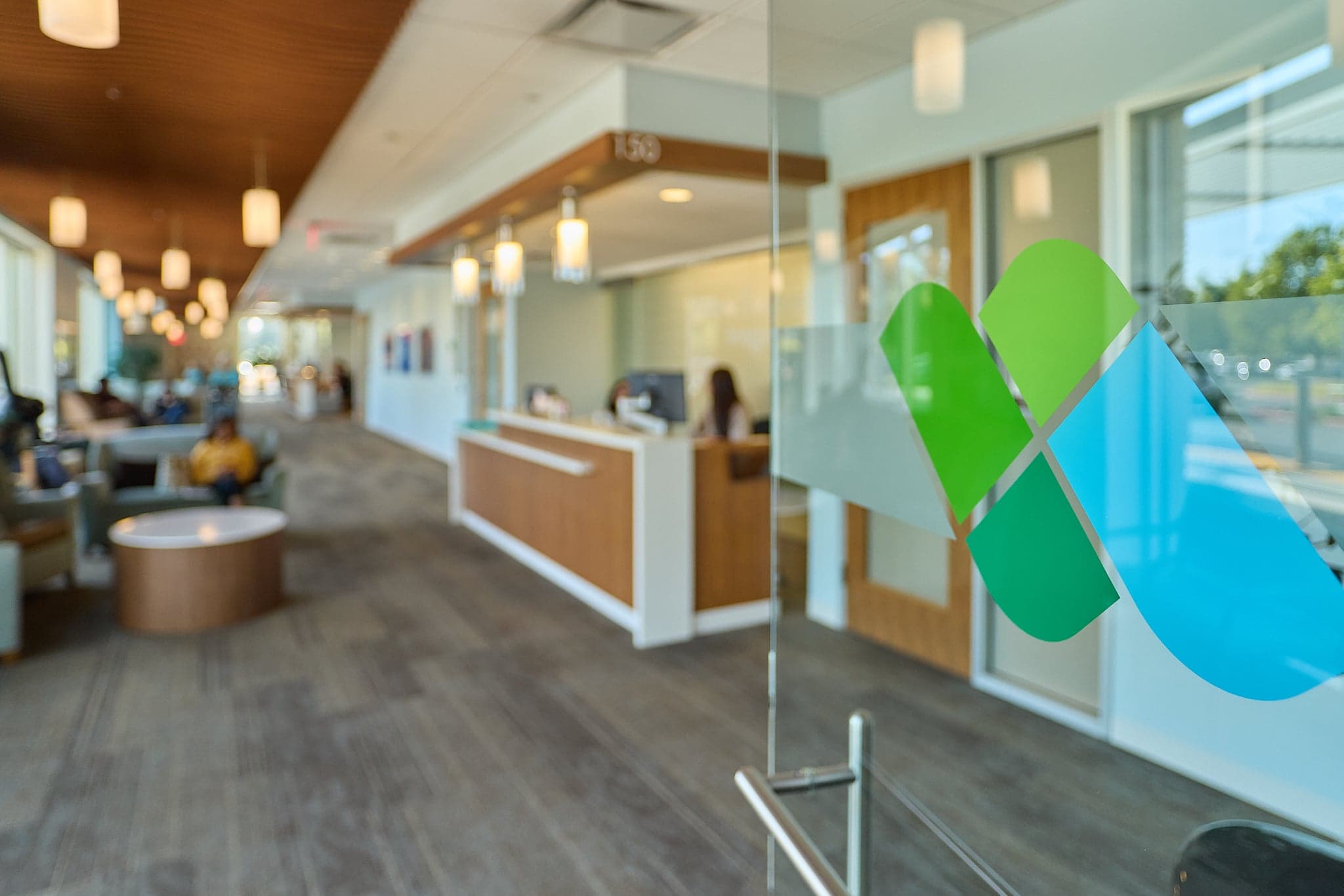 A hallway at a medical clinic with a logo on the door.